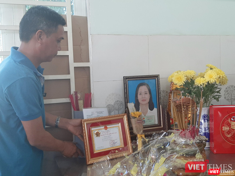 Anh Trần Bá Trình trân trọng đặt bằng khen của Bộ Y tế lên bàn thờ người vợ quá cố. Ảnh: Nguyễn Trăm
