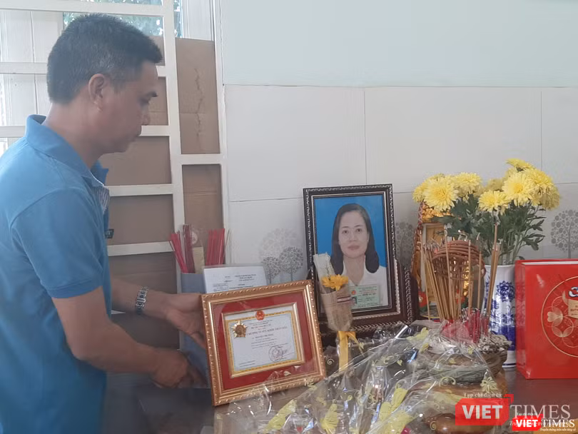 Anh Trần Bá Trình trân trọng đặt bằng khen của Bộ Y tế lên bàn thờ người vợ quá cố. Ảnh: Nguyễn Trăm