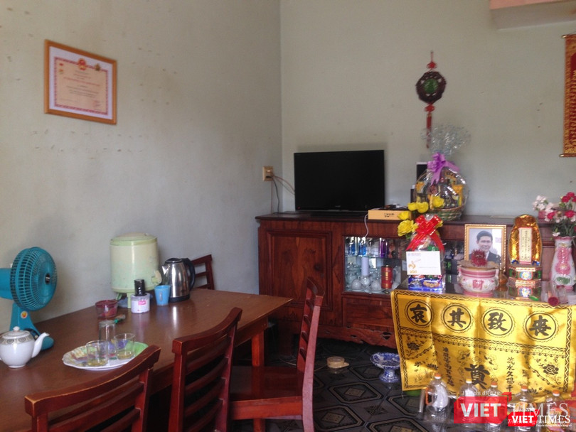 Bà trịnh trọng đặt bằng khen và kỷ niệm chương của Bộ Y tế tặng cạnh bên bàn thờ chồng. Ảnh: Nguyễn Trăm