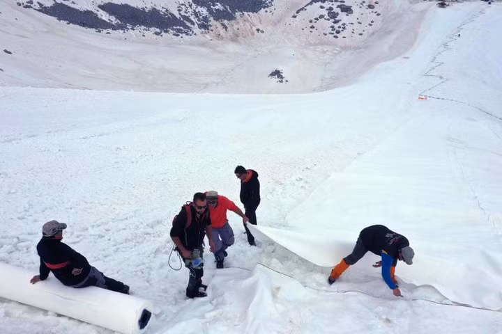 Các công nhân đang phủ bạt lên sông băng. Ảnh: Internet