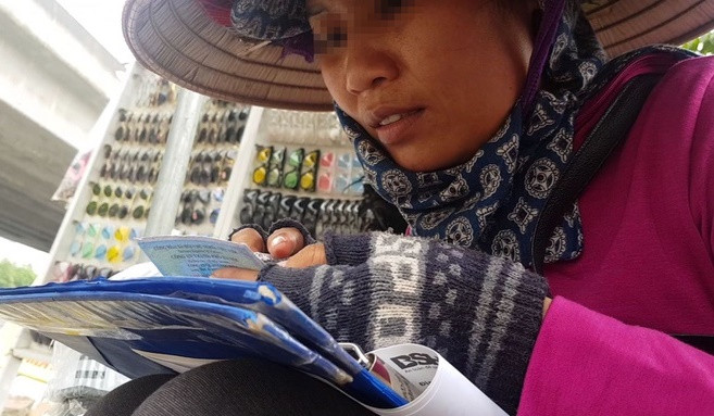 Người phụ nữ bán bảo hiểm xe máy bên vỉa hè. Ảnh: Zing Người phụ nữ bán bảo hiểm xe máy bên vỉa hè. Ảnh: Zing