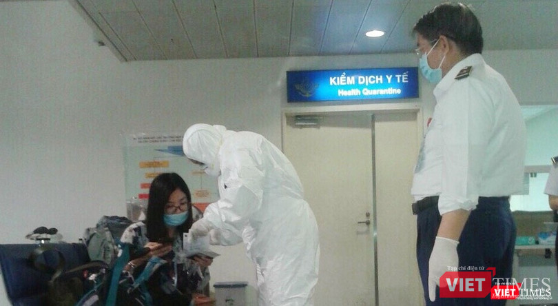 Nhân viên mặc đồ bảo hộ khi tiếp xúc với hành khách thuộc diện cách ly. Ảnh: H.U