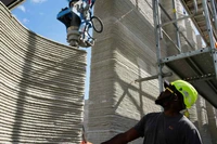 Một cánh tay robot thuộc hệ thống sản xuất bồi đắp đang xếp chồng các lớp bê tông để xây dựng tòa nhà in 3D lớn nhất châu Âu tại Heidelberg, Đức. Ảnh: Nikkei Asia.