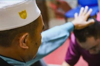 Abdul Manaf Jusoh (bên trái), chủ tịch Trung tâm Điều trị Hồi giáo Darussalam ở Bangi, đang thực hiện nghi lễ cho một bệnh nhân. Ảnh: Nikkei Asia.