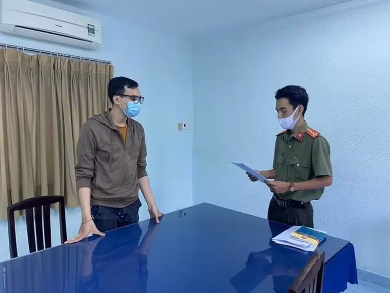 Công an tống đạt quyết định khởi tố bị can Dương Tấn Hậu (trái). Ảnh- CAHS