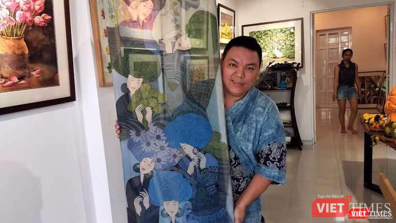 Hoạ sĩ Hà Hùng Dũng với bức tranh gốc ở Cọ Gallery TPHCM. Ảnh: Hoà Bình