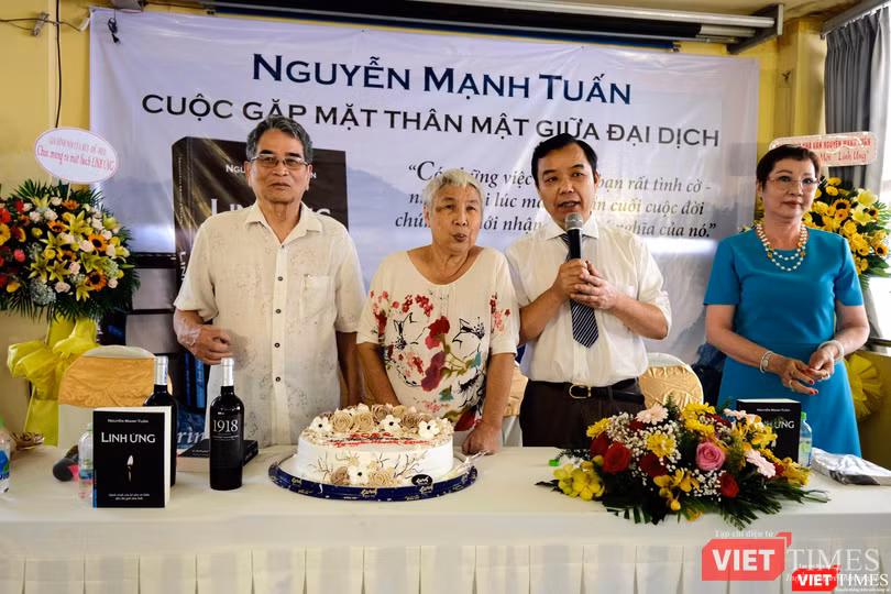 Nhà văn Nguyễn Mạnh Tuấn cùng vợ chuẩn bị cắt bánh chúc mừng vì cuốn sách "Linh ứng" được phát hành