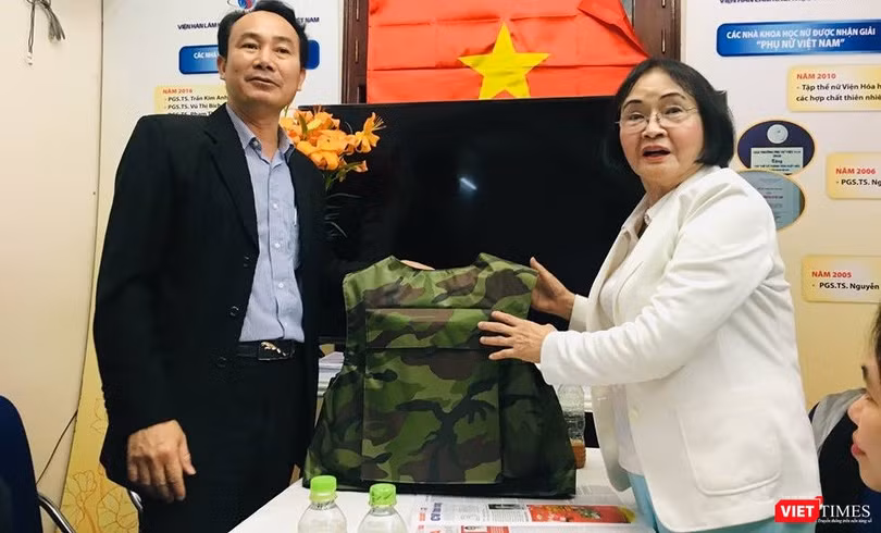 Đại diện Z117 và PGS.TS. Nguyễn Thị Hòe giới thiệu chiếc áo chống đạn sẽ được sử dụng sơn chống đạn và sơn chống cháy. (Ảnh: T.H)