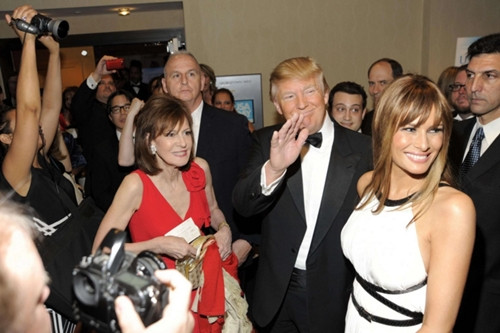 Tỷ phú Donald Trump (giữa) và vợ mình (áo trắng) trong vòng vây phóng viên. Ảnh:AP Tỷ phú Donald Trump (giữa) và vợ mình (áo trắng) trong vòng vây phóng viên. Ảnh:AP