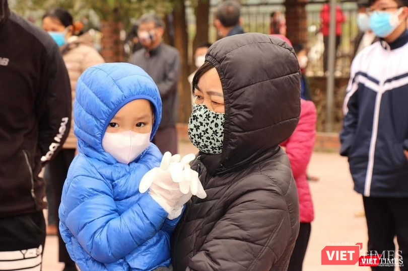 Các em nhỏ được gia đình trang bị bảo hộ đi lấy mẫu xét nghiệm
