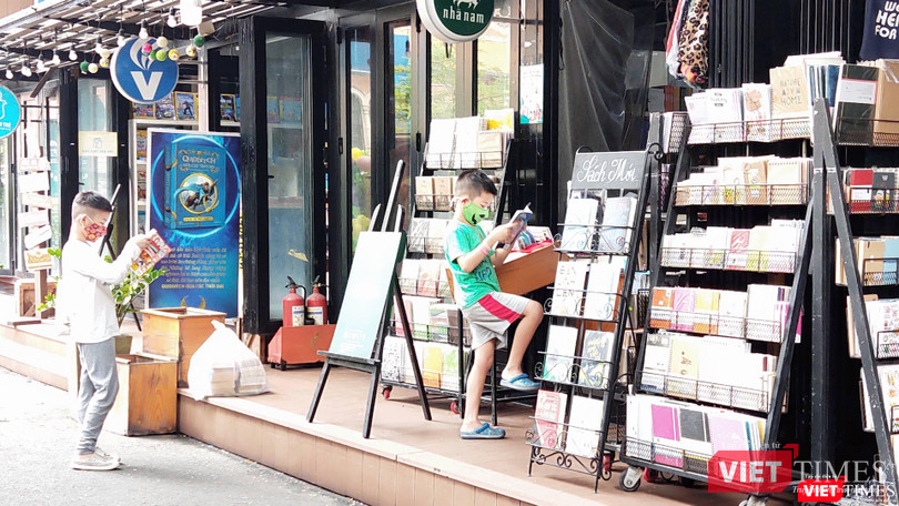 Nhiều em nhỏ say sưa đọc ngay những cuốn sách cha mẹ vừa mua tặng. Ảnh: Hoà Bình