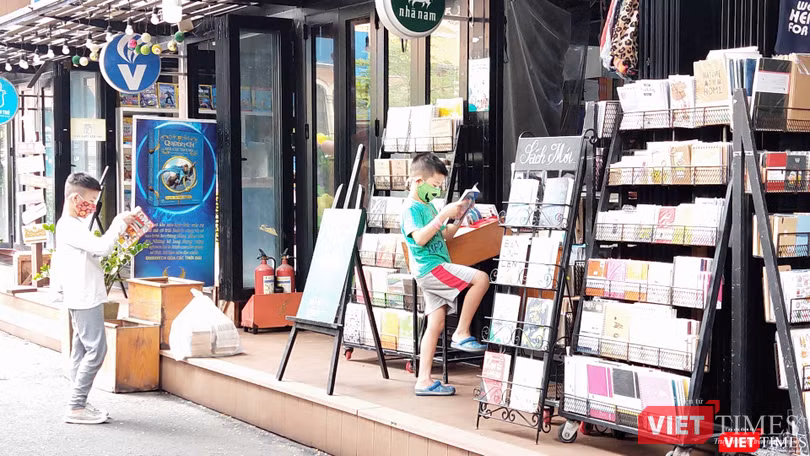 Nhiều em nhỏ say sưa đọc ngay những cuốn sách cha mẹ vừa mua tặng. Ảnh: Hoà Bình