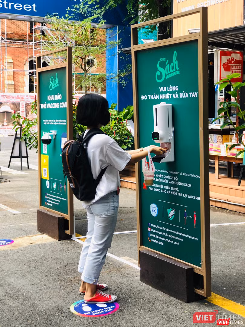 Độc giả đo thân nhiệt và rửa tay trước khi vào Đường sách