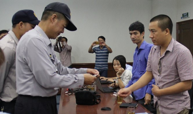 Nhân viên Formosa kiểm tra thẻPV tham dự buổi họp báo - Ảnh: Hồ Văn