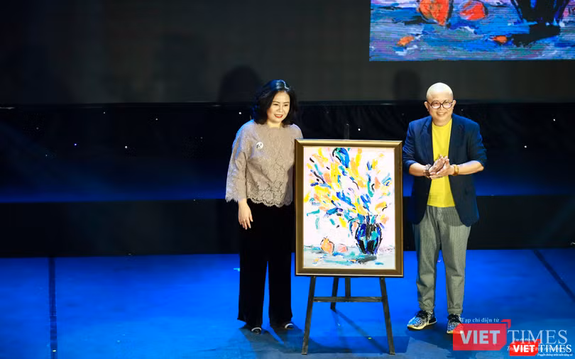 Chị Hồng (bên trái ảnh) người mua tác phẩm "Lay ơn, Huệ tây và hoa đậu biếc trước gió" – Tác giả - hoạ sĩ Lê Kinh Tài (bên phải ảnh) được đấu giá thành công 9000$