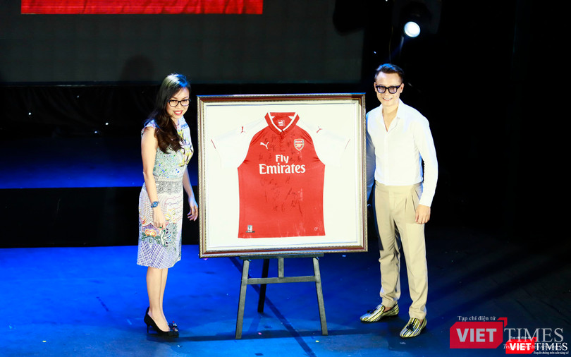 Người tặng áo (bên trái ảnh) và ca sĩ Hoàng Bách lên nhận thay vợ đã đấu giá thành công chiếc áo có chữ ký của các cầu thủ đội tuyển Arsenal - 1000$ Người tặng áo (bên trái ảnh) và ca sĩ Hoàng Bách lên nhận thay vợ đã đấu giá thành công chiếc áo có chữ ký của các cầu thủ đội tuyển Arsenal - 1000$