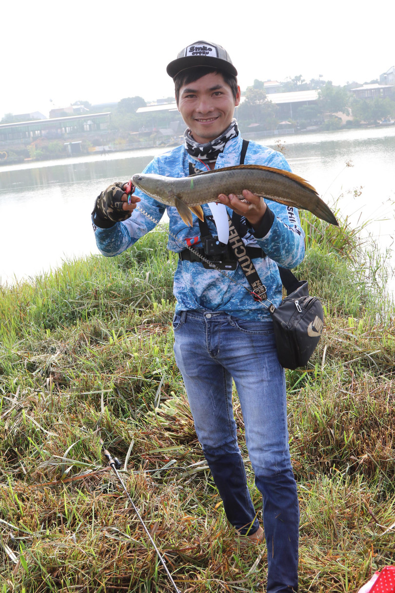 Anh ta trưng con cá lóc lên cho ban giám khảo và phóng viên ảnh xem. Sau đó, anh tá tiếp tục câu ở cái ao nhỏ xíu này, và bắt nốt con cá lóc chồng (hay vợ) cho đủ một đôi.