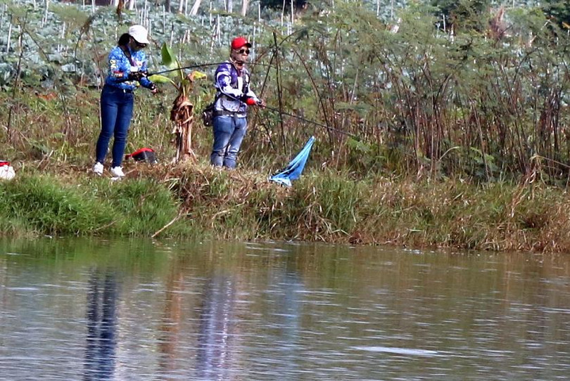 Bên kia bờ hồ, nữ cần thủ tên Lý, vợ của Chủ tịch Hội Cần thủ, đã câu được cá.
