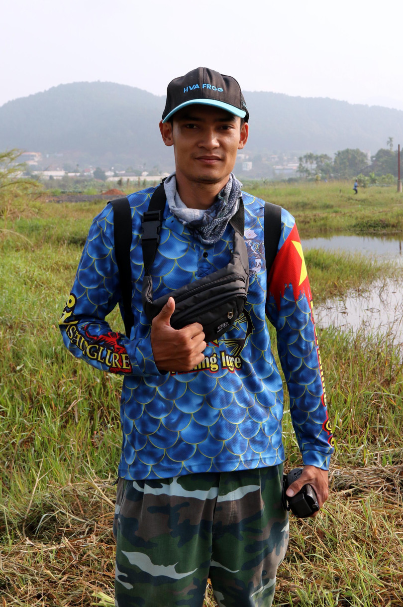 Thanh niên này có công giúp "lão phóng viên ảnh" đã 61 tuổi, bị sụp hổ, ướt hết cả nửa người. Đường đi quanh hồ toàn lau sậy, mới được chặt mấy hôm trước nên chỉ có cần thủ mới biết đâu là lau sậy, đâu là đường đất, còn "lão phóng viên thì không". May mà máy không ướt, và phóng sự ảnh vẫn tiếp tục được thực hiện. Thế là anh ta phải nhận nhiệm vụ đưa "lão phóng viên" thoát khỏi "vùng có bẫy".