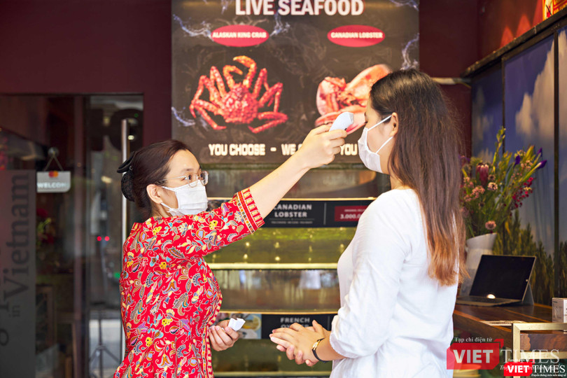 Đo thân nhiệt cho khách vào nhà hàng, kiểm tra khai báo y tế, thẻ xanh COVID-19. Ảnh: HB