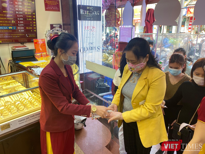 Khách hàng được đo nhiệt độ và sát khuẩn tay trước khi vào cửa hàng Khách hàng được đo nhiệt độ và sát khuẩn tay trước khi vào cửa hàng