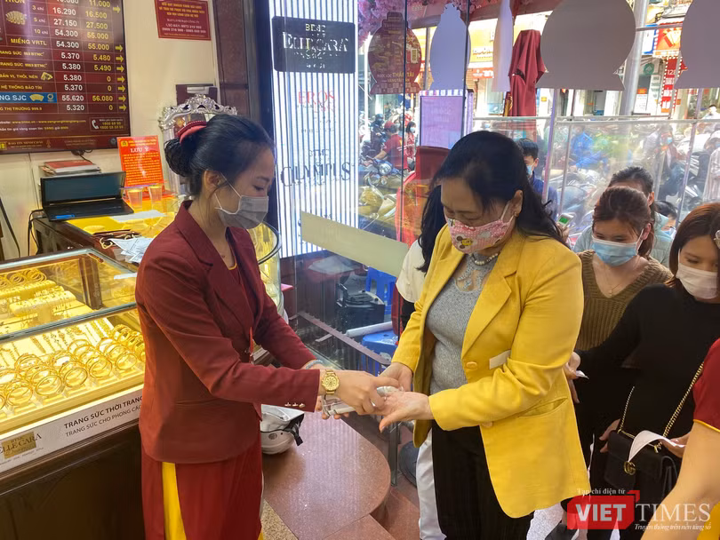 Khách hàng được đo nhiệt độ và sát khuẩn tay trước khi vào cửa hàng Khách hàng được đo nhiệt độ và sát khuẩn tay trước khi vào cửa hàng