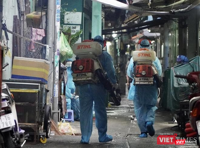 Lực lượng chức năng phun khử khuẩn khu vực BN sinh sống - Ảnh: HCDC
