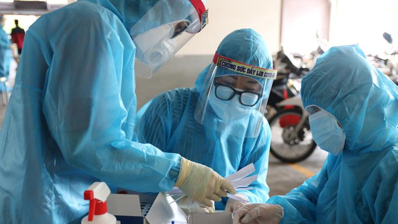 Nhân viên y tế lấy mẫu xét nghiệm trong khu vực phong tỏa - Ảnh: HCDC