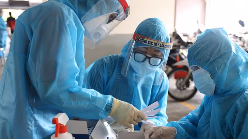 Nhân viên y tế lấy mẫu xét nghiệm trong khu vực phong tỏa - Ảnh: HCDC