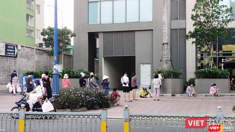 Chờ đợi quá lâu, nhiều người ngồi xuống hè phố giữa nắng trưa. Ảnh: Hoà Bình Chờ đợi quá lâu, nhiều người ngồi xuống hè phố giữa nắng trưa. Ảnh: Hoà Bình