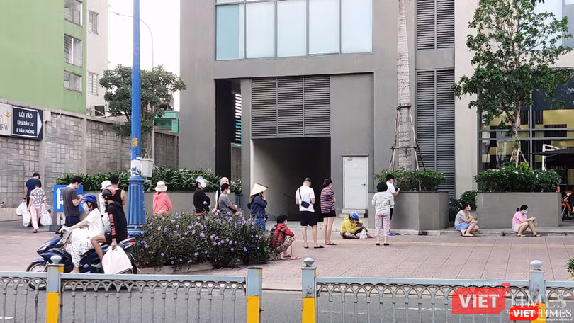 Chờ đợi quá lâu, nhiều người ngồi xuống hè phố giữa nắng trưa. Ảnh: Hoà Bình Chờ đợi quá lâu, nhiều người ngồi xuống hè phố giữa nắng trưa. Ảnh: Hoà Bình