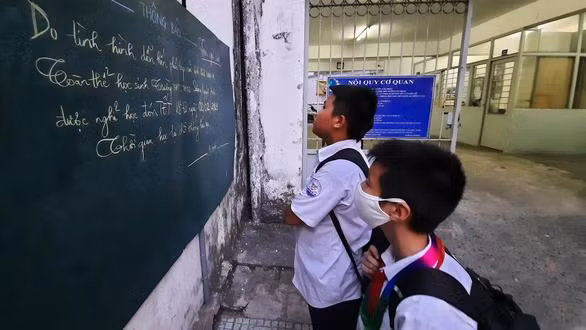 Học sinh Trường THCS - THPT Sương Nguyệt Anh (Q.10, TP.HCM) xem thông báo nghỉ học tránh dịch - Ảnh: Như Hùng 