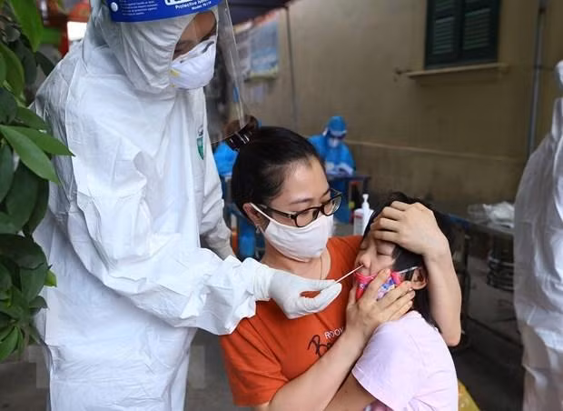 Lấy mẫu xét nghiệm cho trẻ - Ảnh: TTXVN