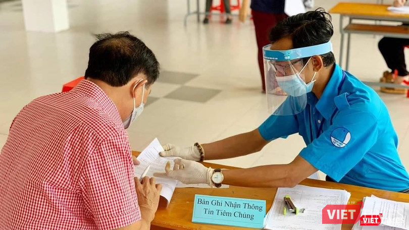 Tình nguyện viên lấy thông tin của người được tiêm chủng COVID-19. Ảnh: HCDC