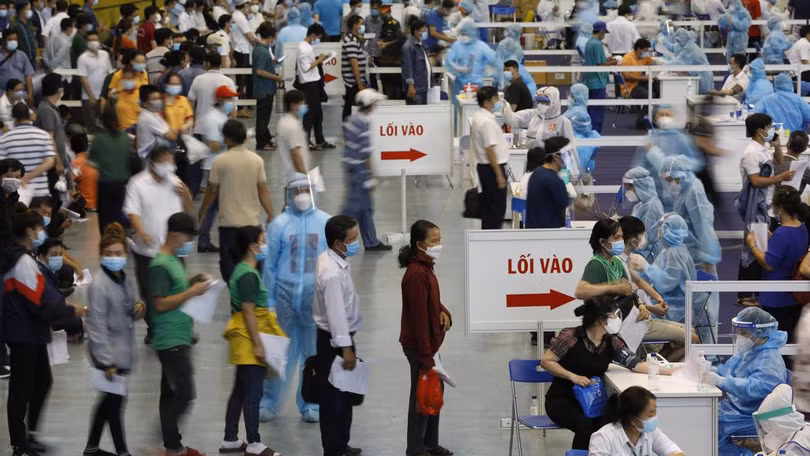 Người dân chờ để vào khu vực tiêm vaccine COVID-19 - Ảnh VNE Người dân chờ để vào khu vực tiêm vaccine COVID-19 - Ảnh VNE