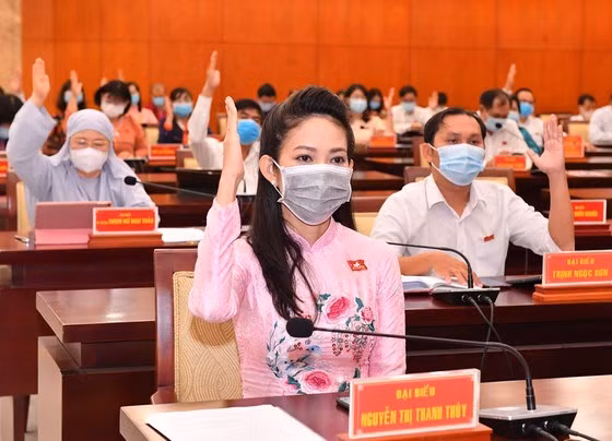 Đại biểu HĐND TP.HCM giơ tay biểu quyết thông qua các nghị quyết - Ảnh: Việt Dũng