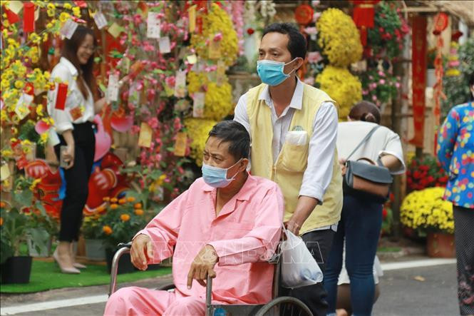 Bệnh nhân và người nhà bệnh nhân tham quan Đường hoa Xuân trong khuôn viên Bệnh viện Chợ Rẫy. Ảnh TTXVN