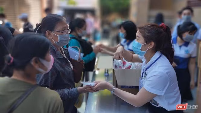 Hướng dẫn người dân khai báo y tế và sát khuẩn, sàng lọc COVID-19 ngay tại khu vực đón tiếp của BV Đại học Y Dược TP.HCM (Ảnh: Hoà Bình) 