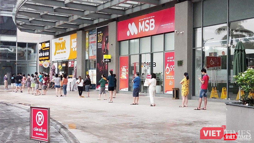 Hàng trăm người dân xếp hàng cả tiếng trước cửa một siêu thị tại quận 4. Siêu thị này cung cấp thực phẩm cho khoảng 2.000 căn hộ - Ảnh: Hoà Bình