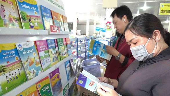 Phụ huynh ở TP.HCM đang chọn mua sách giáo khoa cho con - Ảnh- NHƯ HÙNG