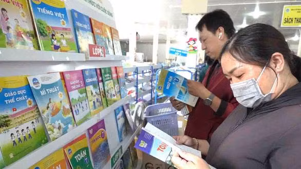 Phụ huynh ở TP.HCM đang chọn mua sách giáo khoa cho con - Ảnh- NHƯ HÙNG