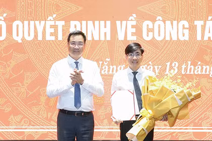 Ông Lê Ngọc Quang, Bí thư Thành ủy Đà Nẵng trao quyết định và tặng hoa chúc mừng ông Trần Thắng Lợi. Ảnh Hồng Quân.