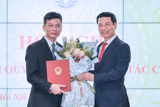 Bộ trưởng Bộ Thông tin và Truyền thông Nguyễn Mạnh Hùng trao quyết định bổ nhiệm chức danh Thư ký Bộ trưởng cho ông Lê Thái Hòa. (Ảnh: Lê Anh Dũng)