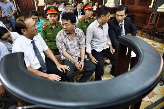 Nguyễn Minh Hùng và Nguyễn Mạnh Cường trước giờ xét xử - Ảnh: HỮU KHOA