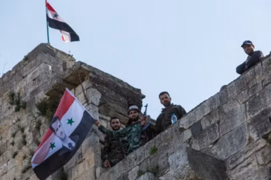 Cờ Syria được các binh sĩ gương cao trên tòa nhà mới chiếm lại
