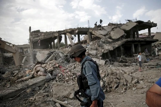 Một cảnh sát Afghanistan tại hiện trường vụ đánh bom xe - Ảnh: Reuters