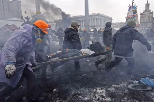 Một người bị thương trong cuộc đụng độ tháng 2/2014 tại Quảng trường Maidan. Ảnh: Reuters