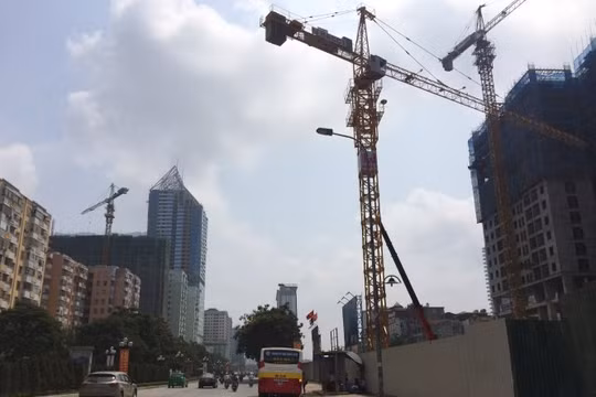 Hàng loạt cần cẩu công trường xây dựng lơ lửng đe dọa an toàn cho người đi đường trên đường Lê Văn Lương (Hà Nội) - Ảnh: Lâm Hoài