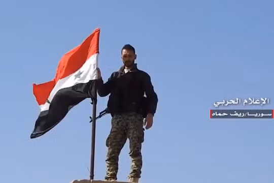 Một binh sĩ Syria thượng cờ trên thị trấn vừa giải phóng. Video truyền thông Hezboaah