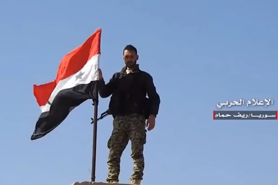 Một binh sĩ Syria thượng cờ trên thị trấn vừa giải phóng. Video truyền thông Hezboaah